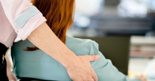 Woman being touched unwillingly by a coworker.