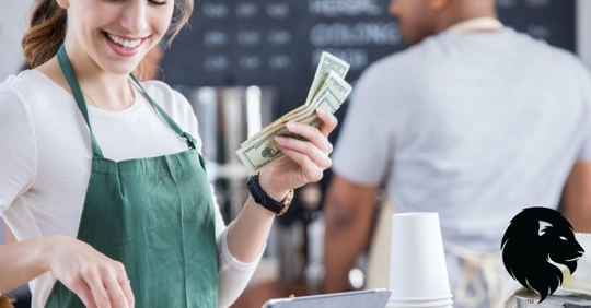 Smiling waitress in coffee shop holding money at register