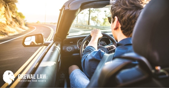 man in a convertible car driving on highway
