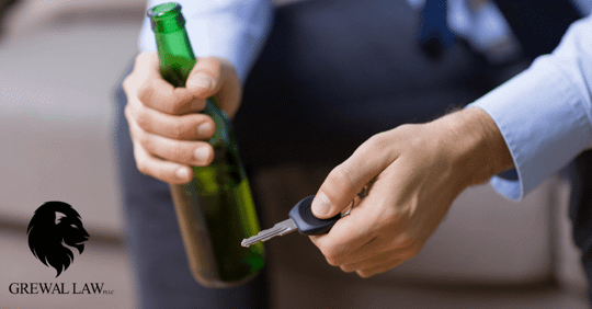 image of a man's hand holiding a beer bottle and his other hand holdking a car key.