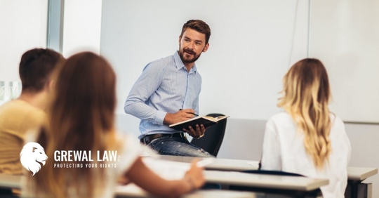 Male teacher in a classroom with male and female students at desks.