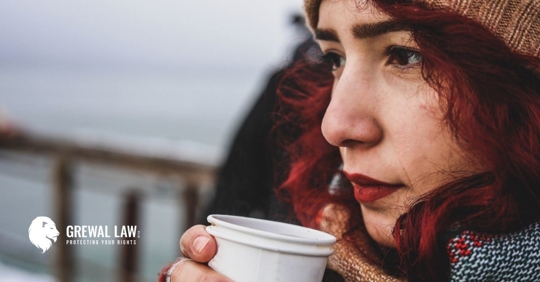 woman in a knit cap with a cup of coffee in her hands.