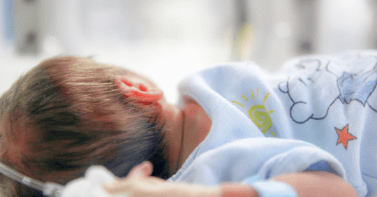 Baby in hospital bassinet.