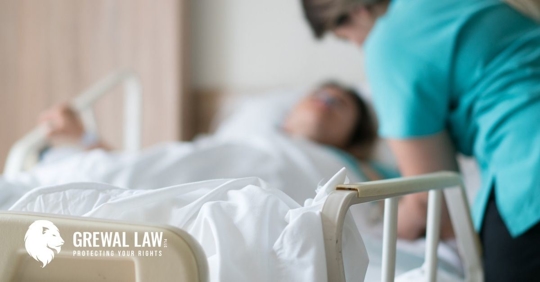 Blurred image of a patient in a hospital bed with a nurse standing over.