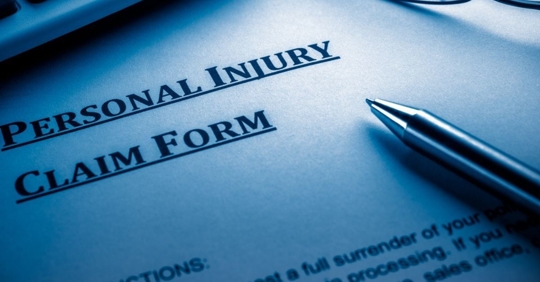 Document that reads, "Personal Injury Claim Form" with a pen on top.
