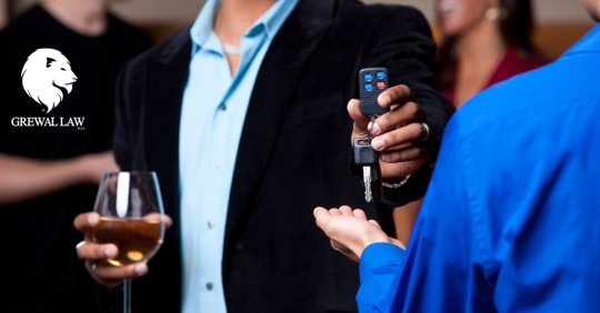 Grewal Law: man holding glass of wine handing over keys to someone else.